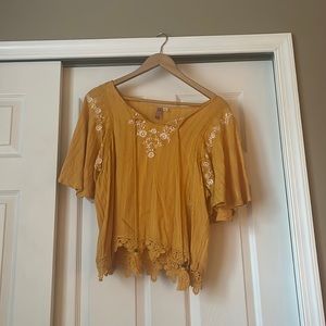 Yellow blouse with white flower accents and lace at the bottom